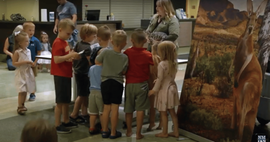 Group of children gathered around to view animals up-close