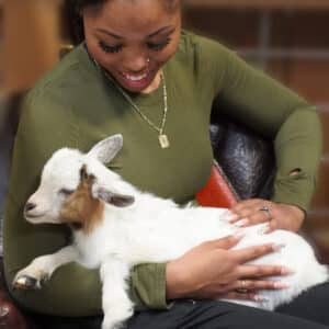 woman holding a baby goat